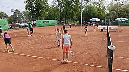 Kinder mit Schlägern bei Übungen auf dem Platz