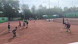 Kinder bei Ballübungen auf mehreren Plätzen