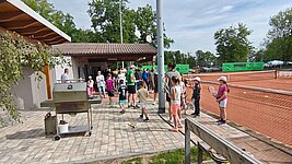 Kinder und Eltern auf der Terrasse am Grill