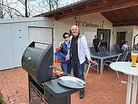 Zwei Personen am Grill vor dem Clubhaus