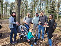 Gruppe mit Kindern und Kinderwagen im Wald